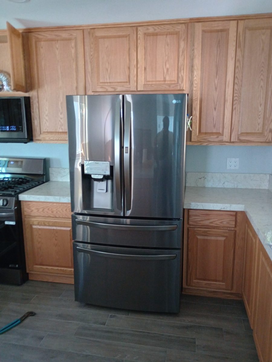French-door refrigerator installed and levelled between kitchen cabinets