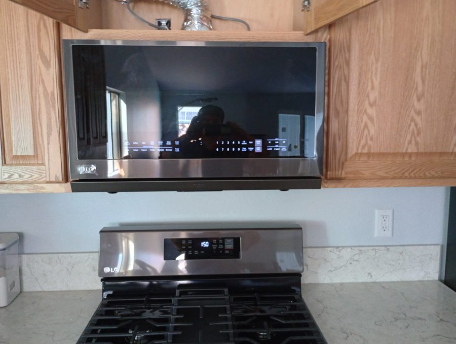 Over-the-range microwave vent routed through the cabinet